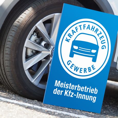 Meisterschild angelehnt an Autoreifen 